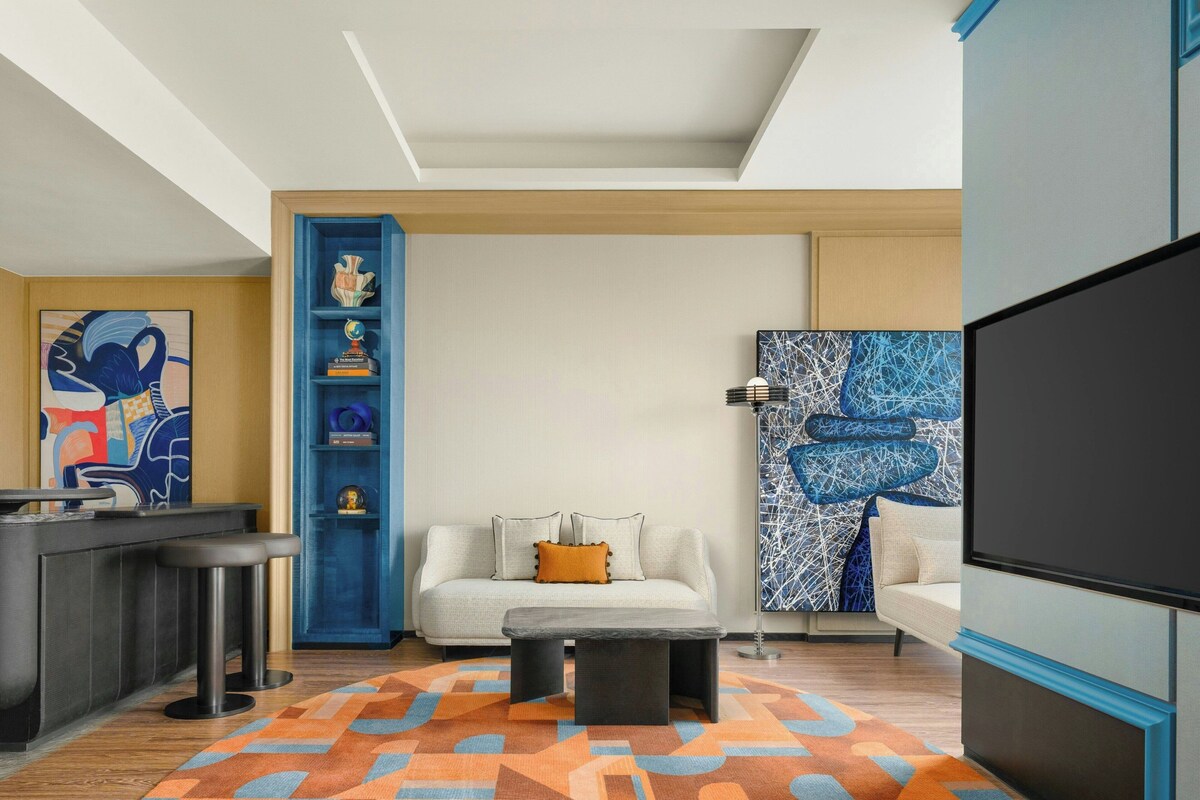 Una sala moderna con un sofá, una mesa de centro y un estante azul.