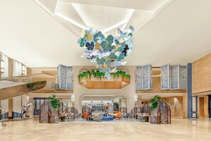 A spacious lobby with a modern design, featuring a central seating area, a staircase, and decorative panels. - Le Méridien Changzhou (Changzhou)