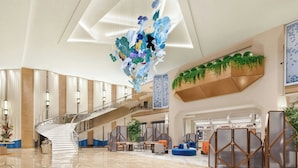 A spacious lobby with a central staircase, seating areas, and a decorative ceiling installation. - Le Méridien Changzhou (Changzhou)