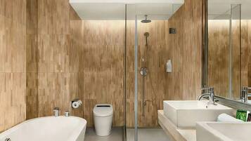 A modern bathroom with a glass-enclosed shower, two sinks, a toilet, and a large mirror.