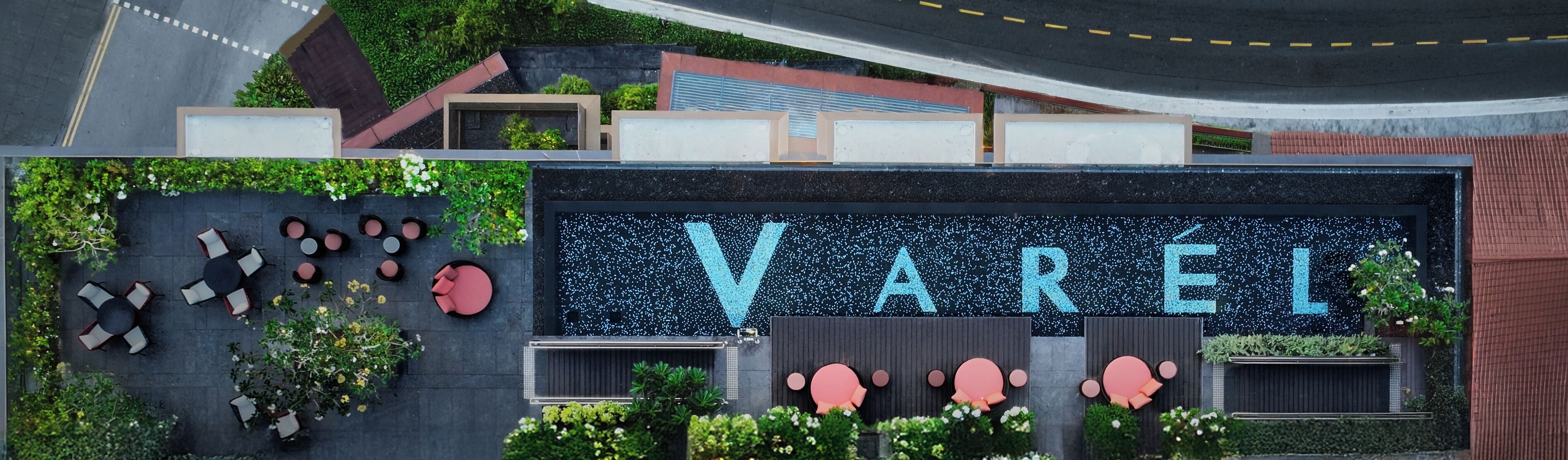 Un bâtiment moderne, reconnaissable à son grand panneau « VAREL », doté d’une terrasse et agrémenté d’un aménagement paysager verdoyant.