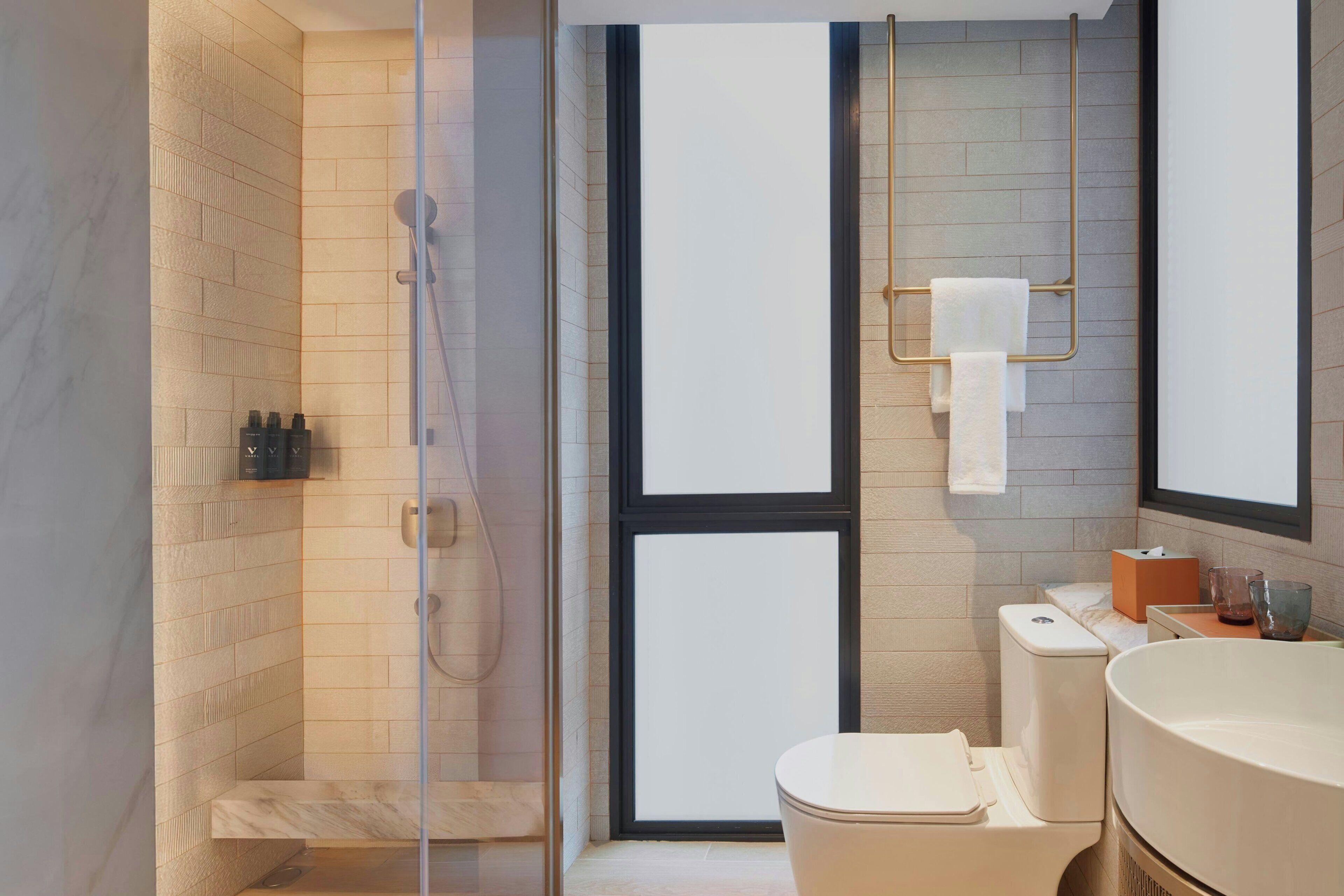 Une salle de bain moderne avec une douche à parois de verre, des toilettes et un lavabo.