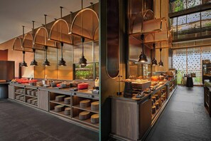Een moderne keuken met meerdere bedieningspunten, verlichting erboven en uitzicht op de omgeving.