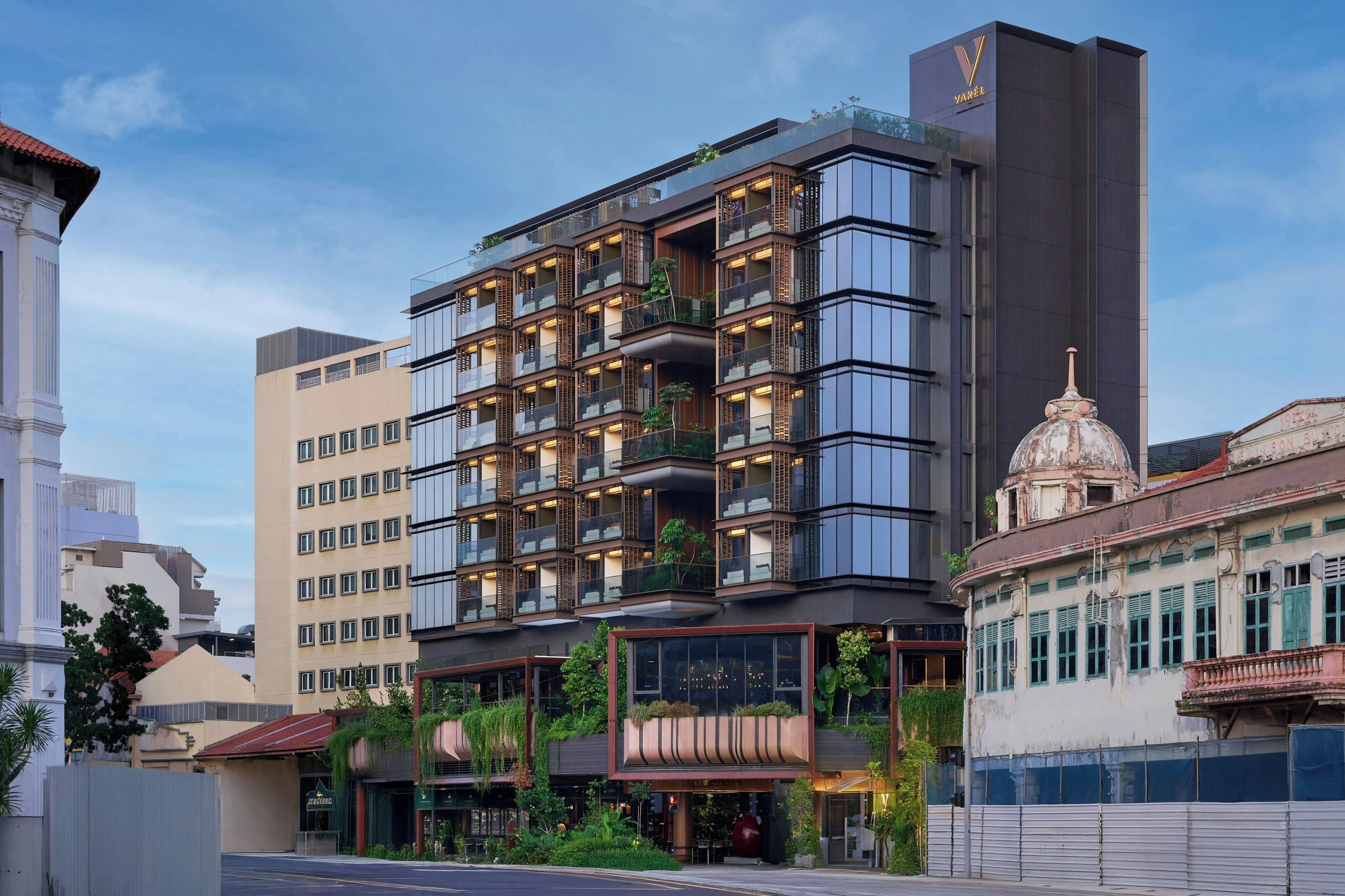 Un hotel de varios pisos con balcones, un restaurante y una estructura en forma de cúpula.