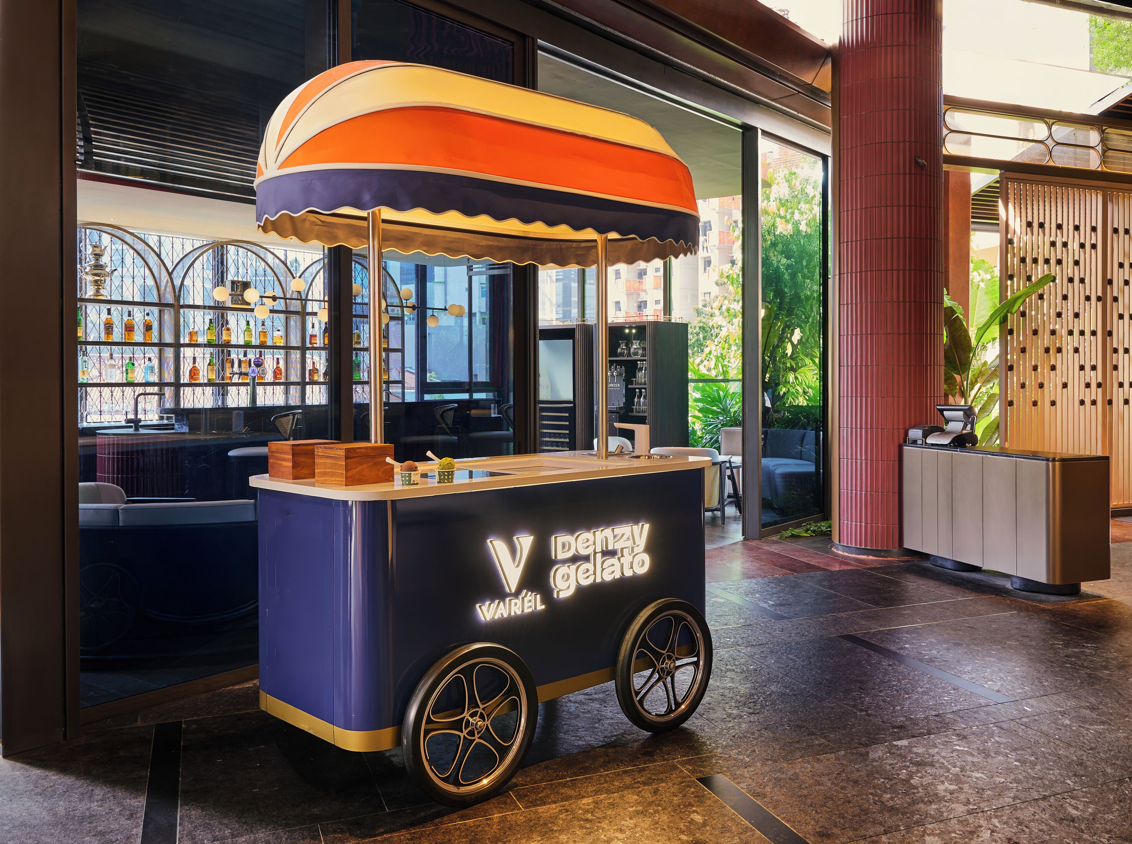 Un carrito de helados con un paraguas de marca en un ambiente interior moderno.