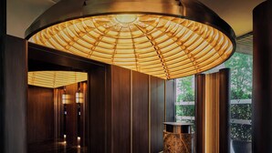 A modern interior with a curved ceiling, a central column, and a view of greenery outside. - Varel Singapore, A Tribute Portfolio Hotel (Singapore)