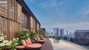 A rooftop terrace with outdoor seating, a pool, and city views.