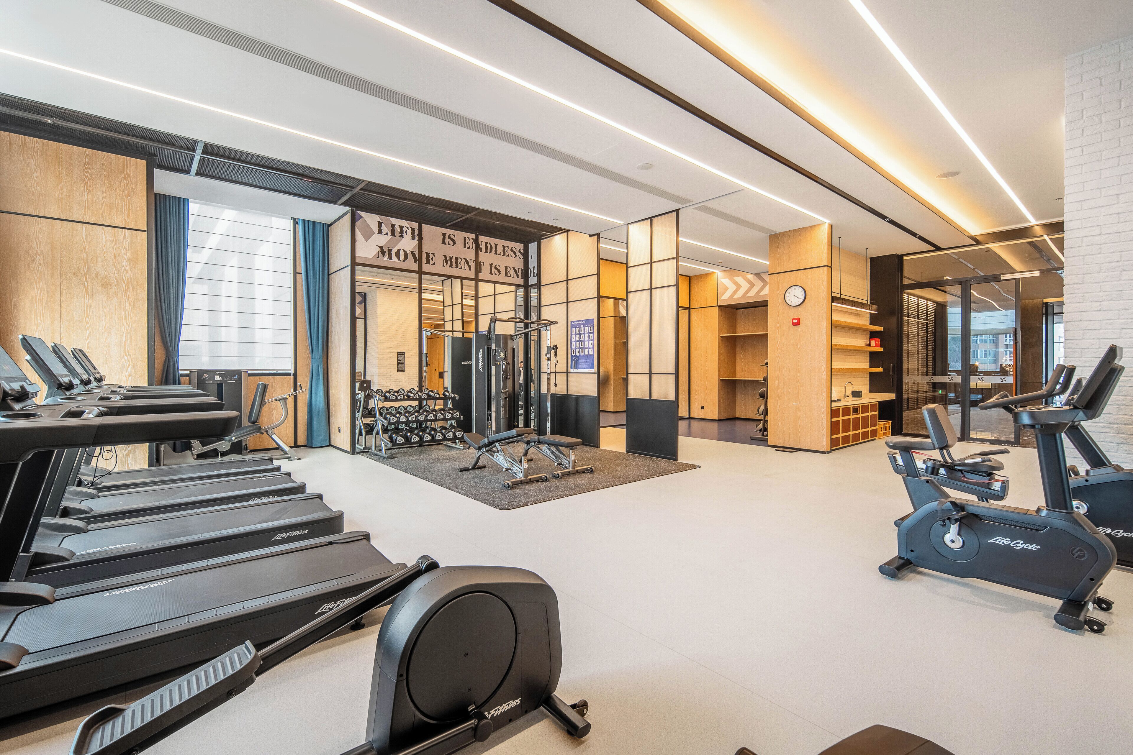 A gym with treadmills, an elliptical, and weight machines.