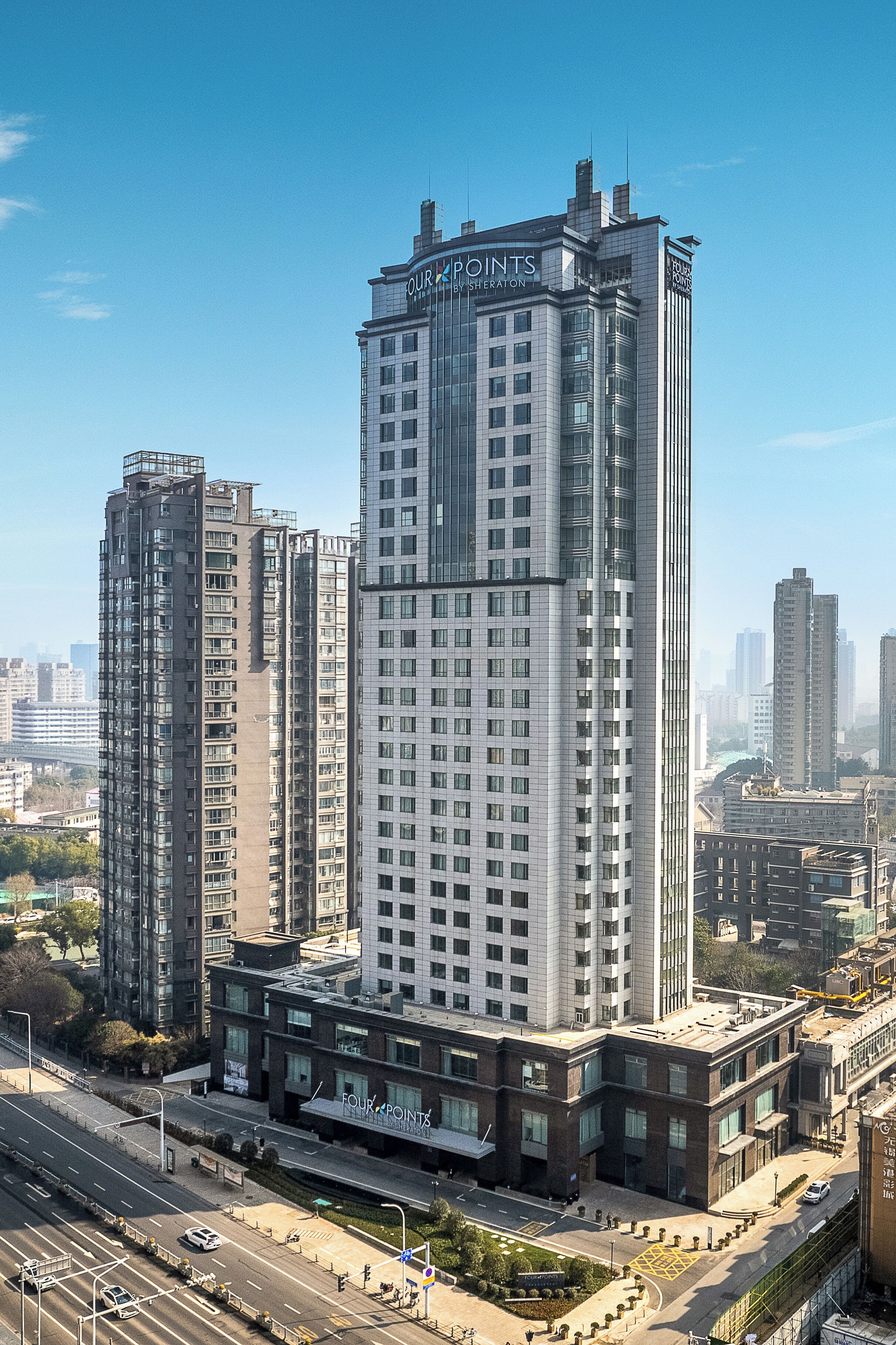 Un edificio de gran altura con letrero 'FOUR POINTS', varios pisos y un diseño arquitectónico moderno.