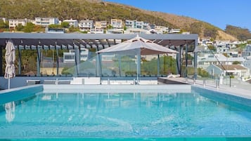 Een buitenzwembad, parasols bij het zwembad en ligstoelen