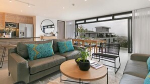 Un salon moderne avec un canapé, une table basse et un coin repas.