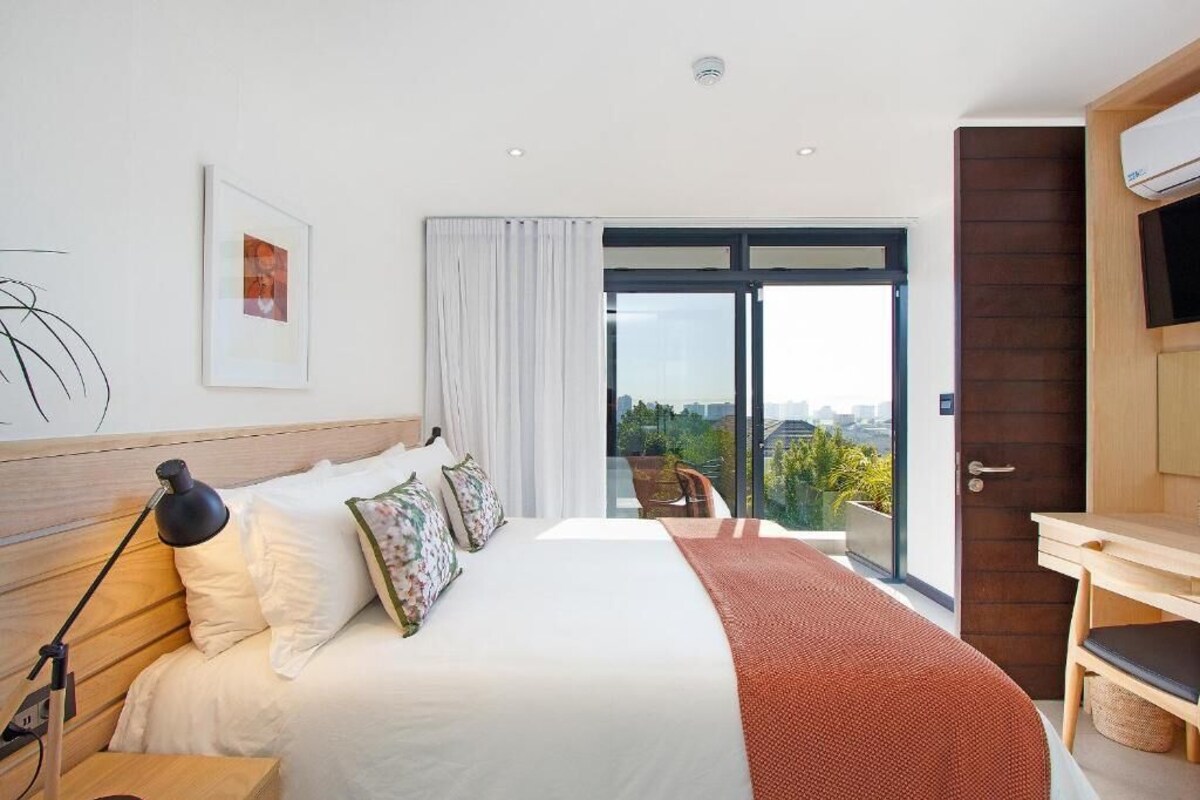 Une chambre d’hôtel moderne, dotée d’un grand lit, d’un bureau et d’une télévision.
