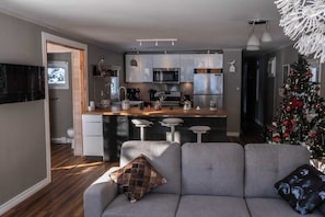 A modern kitchen with stainless steel appliances, a bar area, and a Christmas tree.