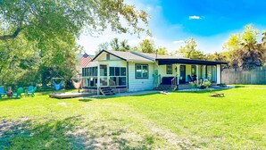A single-story house with a porch, a small deck, and a fenced backyard. - 3Br 2Ba Cottage w/ Golf Cart (Waveland)