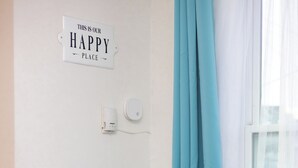 A small room with a blue table and chairs, a potted plant, a sign on the wall, and a window with curtains. - Quiet & Walkable - Stampede, BMO, Nightlife & Eats - Apartment (Calgary)