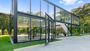 Ein modernes Glasgebäude mit einer Treppe, die zu einer oberen Ebene führt.