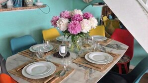 Una mesa de comedor dispuesta con platos, cubiertos y un florero.