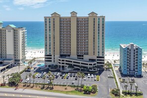 Un hotel de varios pisos con estacionamiento y vistas a la playa.