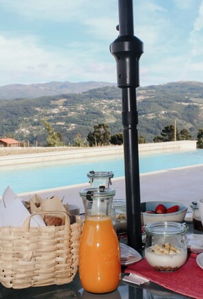 A breakfast table with a view of a swimming pool and mountains. - Canhoto Douro (São Lourenço do Douro)