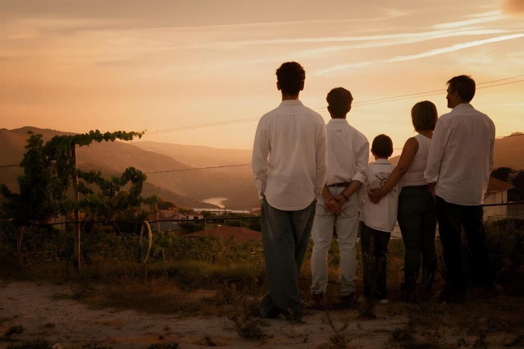 A group of people standing on a hill overlooking a valley with mountains in the distance.
