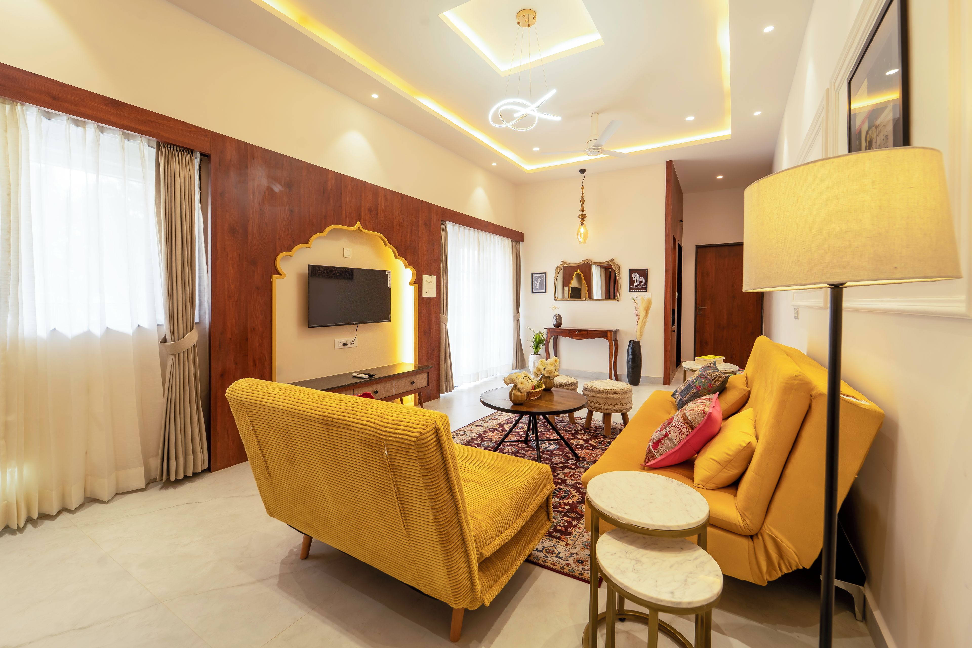 Una sala de estar moderna con un sofá, un sillón y un televisor montado en la pared.