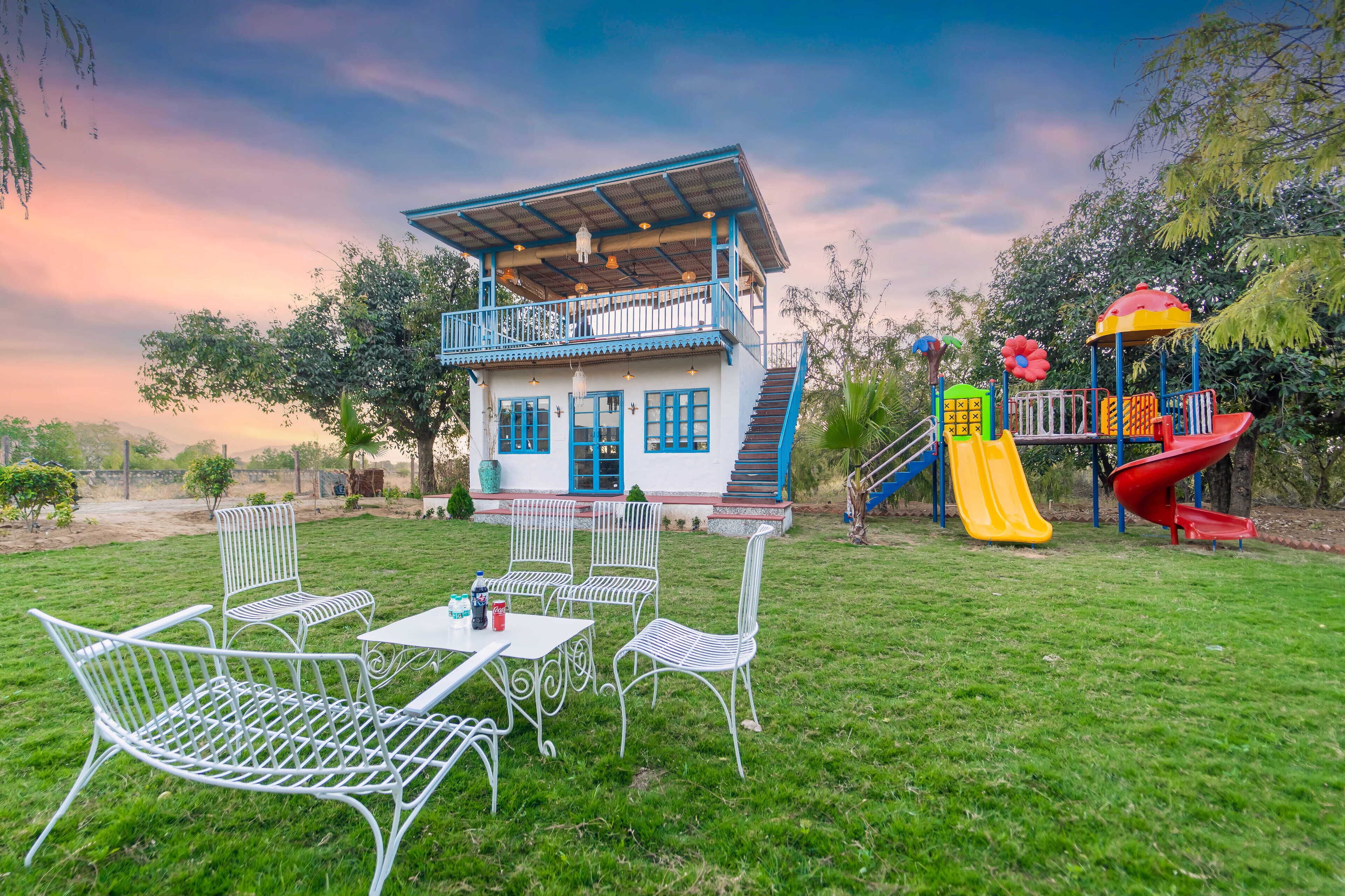 A two-story building with a balcony, a slide, and a play area.