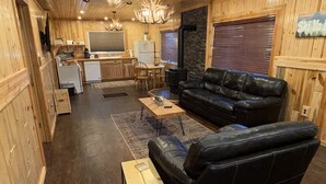 Een chalet met woonruimte, keuken en een eethoek.