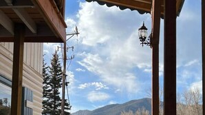 Una terraza de madera que lleva a un edificio con vista a la montaña.
