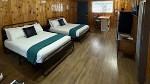 A room with two beds, a desk, a chair, a refrigerator, and a window. - Room 10 at Bellamy's (Red River)