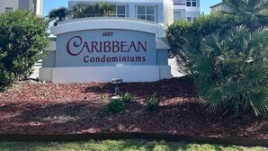 Um edifício alto com uma placa que diz 'Caribbean Condominiums' na base.