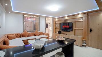 Dúplex Deluxe | Zona de estar | Smart TV de 90 pulgadas con canales por cable