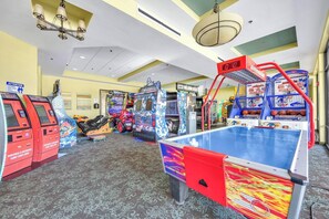 Un salón de juegos con varias máquinas, incluyendo una mesa de baloncesto, y un marcador digital que muestra 0.8.