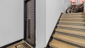 A staircase with a metal railing and a door with horizontal slats. - Cozy 2-bedroom apartment in beautiful București with AC (București)