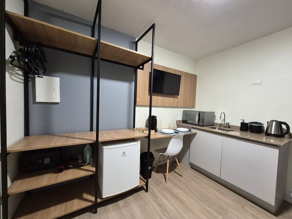 Una cocina compacta equipada con microondas, hervidor y cafetera.