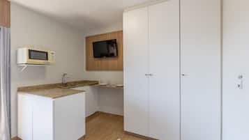 Cozinha equipada com micro-ondas, televisão e pia.
