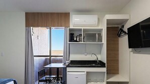 A compact kitchenette with a microwave, coffee maker, and a small refrigerator. - Studios at Upper Residence - Upps II (Curitiba)