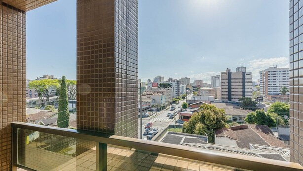 A high-rise building with a clear view of a cityscape, including various buildings and a street with vehicles. - Studios at Upper Residence - Upps II (Curitiba)