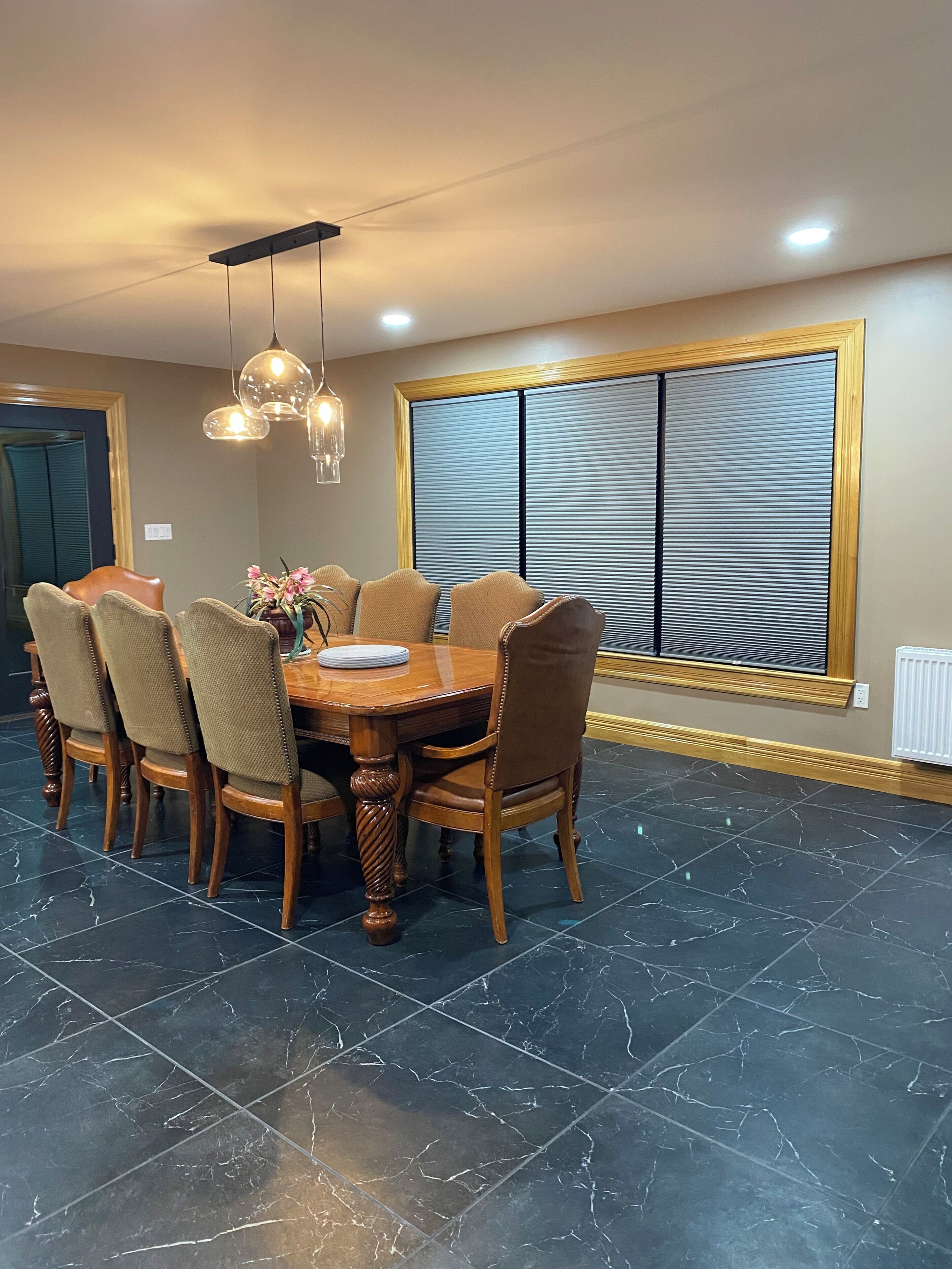 A dining area with a round table, six chairs, and a decorative vase.