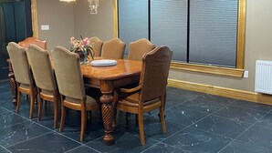 A dining area with a round table, six chairs, and a decorative vase. - Eagle Heights: luxurious Sebago Lake retreat sleeps 8+ (Sebago)