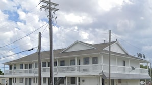 Motel de dos pisos amb un balcó al segon pis, un porxo cobert a la façana i antenes parabòliques a la teulada.
