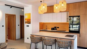 A modern kitchen with a central island, bar stools, and pendant lighting. - 5 stars Luxury Villa in Lopar on island Rab (LOPAR (RAB))