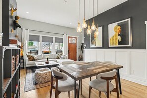 A dining area with a wooden table, chairs, pendant lights, and a view through a window. - Contemporary new craftsman in the heart of Atlanta! 
FIFA Ready (Atlanta)