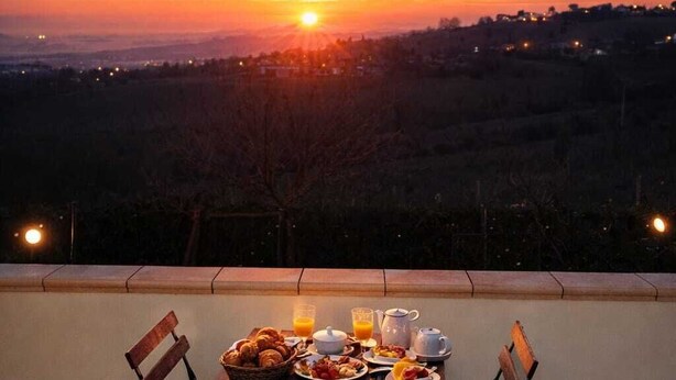 Una mesa preparada para el desayuno con vistas panorámicas al atardecer.
