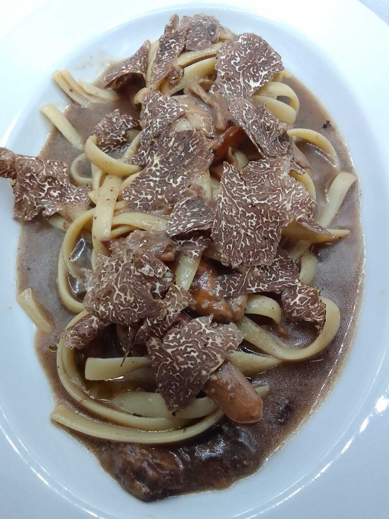 A plate of beef with noodles in a brown sauce.