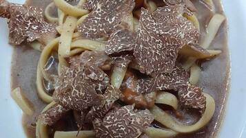 A plate of beef with noodles in a brown sauce.