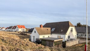 A row of houses with a grassy foreground and a clear sky. - Cozy home in Hanstholm with WiFi (Hanstholm)