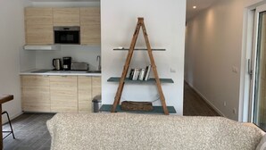 Une cuisine moderne avec des meubles en bois, un four encastré et une machine à café.