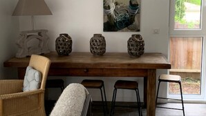 Une table de salle à manger en bois, agrémentée de quatre vases décoratifs, d’une lampe et de deux chaises.