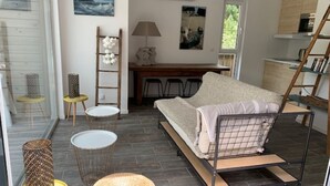 Un salon moderne comprenant un canapé, une table à manger et un coin cuisine.