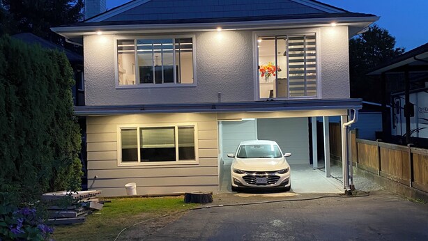 Een tweelaags huis met een garage, oprit en een keurig onderhouden gazon.